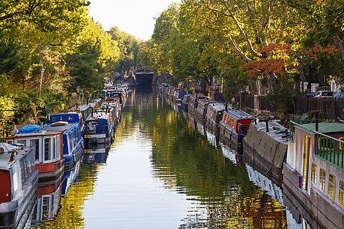 Narrowboats moored along the canal at Little Venice under autumn trees