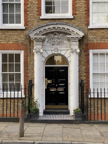 A Georgian doorway on Great James Street, columns either side of a black door under a carved pediment