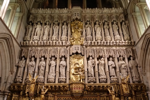 The cathedral's great stone screen: two rows of carved figures in canopied niches, bishops, kings and saints, with a gilded Virgin and Child in the middle and gilt angels at the foot.
