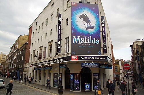 The Cambridge Theatre on Seven Dials, its curved corner and name above the entrance
