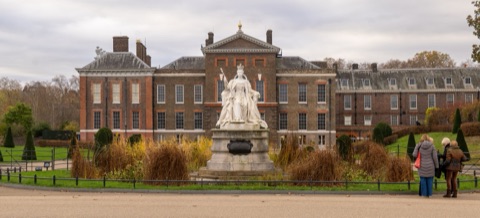 The east front of Kensington Palace in brick, with the marble statue of Queen Victoria on a plinth in front of it