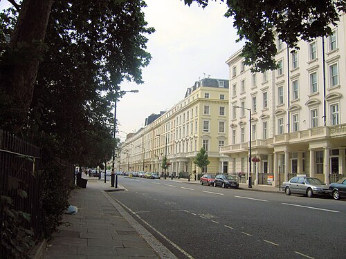 Belgrave Road in Pimlico: a long run of white and cream stucco terraces with columned porches, under plane trees