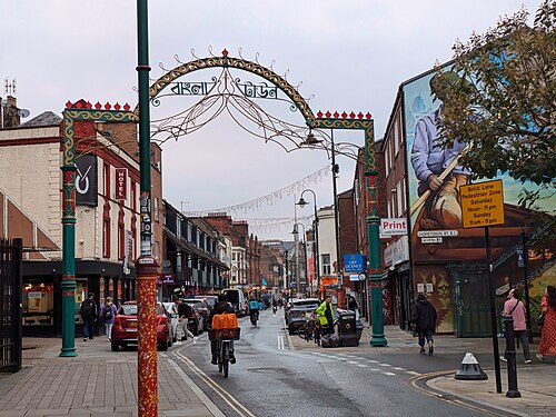 Brick Lane under its Banglatown arch, curry houses and shops along both sides