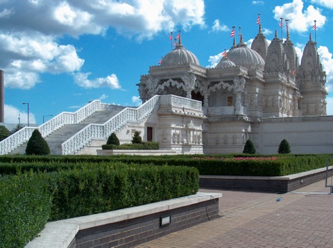 The Neasden mandir's white marble domes and pinnacles above balustraded steps and clipped hedges