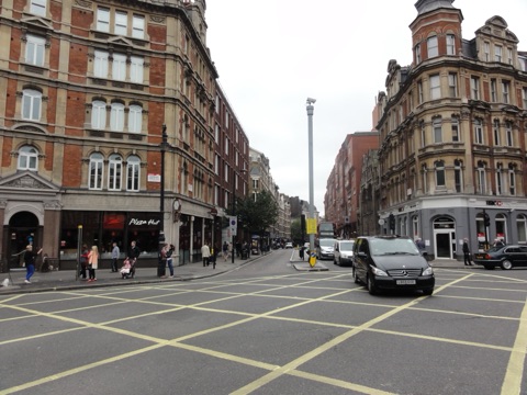 Standing in the traffic island at Cambridge Circus, looking across the traffic junction south down Charing Cross Road