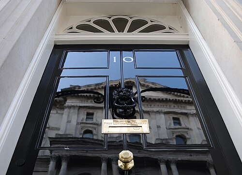 The black front door of 10 Downing Street, its fanlight above and the brass letterbox in the middle