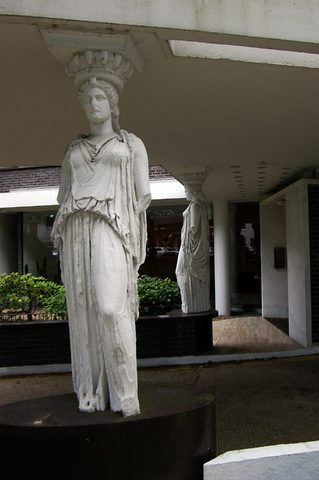 One of the plaster caryatids under the entrance canopy of Highpoint II, the concrete soffit resting on the basket on her head, the second caryatid behind her