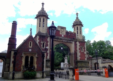 A brick gateway into Lincoln's Inn, turreted, with lamps either side