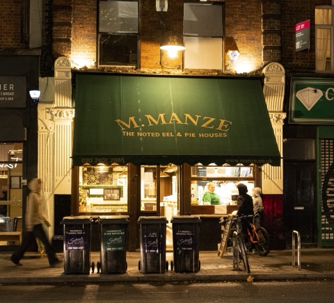 The tiled Victorian shopfront of M. Manze on Tower Bridge Road, with the pie and mash sign above the windows