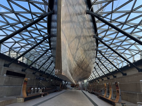 The ship's hull seen from the hall beneath it, the glass canopy meeting the dock on both sides