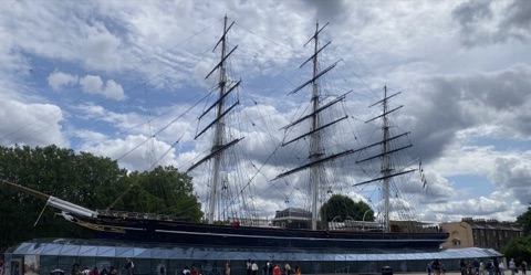 The Cutty Sark's black hull and three masts standing above the glass roof of her dry berth