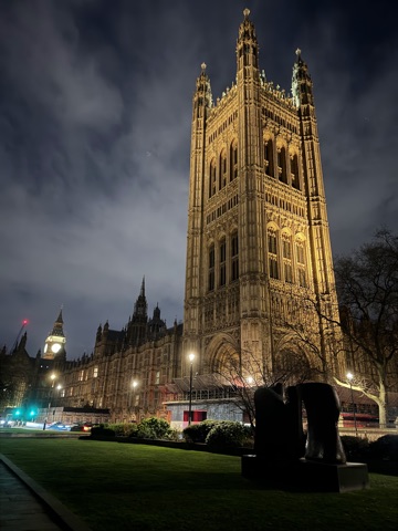 The Victoria Tower floodlit at night, the Elizabeth Tower lit further along