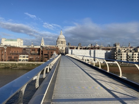 The Millennium Bridge's deck in low winter sun, St Paul's ahead and the City either side