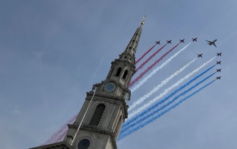 The Red Arrows trailing red, white and blue smoke past St Martin-in-the-Fields' spire