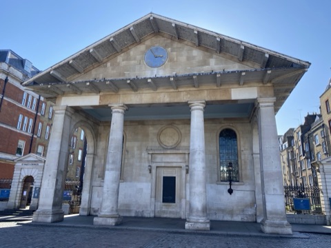 The Tuscan portico of St Paul's Covent Garden facing the piazza, its clock in the pediment