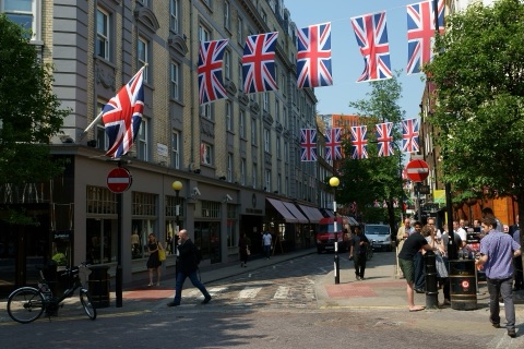 Monmouth Street from Seven Dials, flags strung above the shops