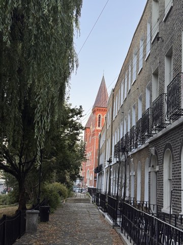 A willow overhanging the garden path along Duncan Terrace, the Georgian terrace on the right and a red brick church spire ahead