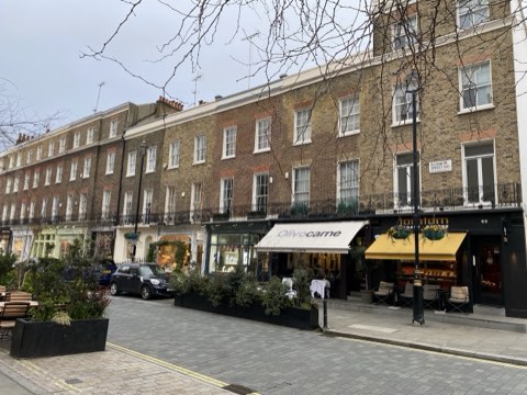 Shopfronts along Elizabeth Street on a winter afternoon, awnings out over the pavement and planters along the kerb