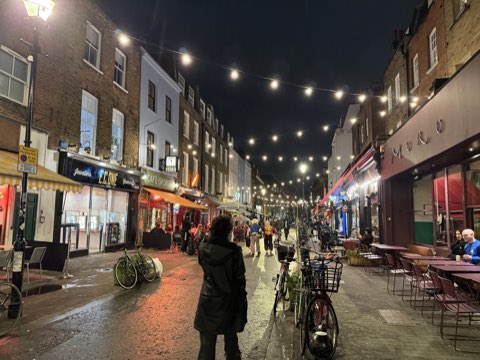 Exmouth Market at night under strings of festoon lights, Moro on the right