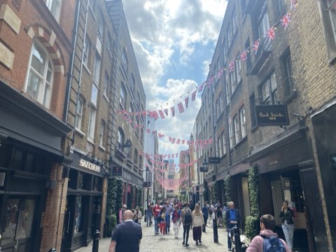 Floral Street from below, Union Jack bunting strung across the narrow cobbled street