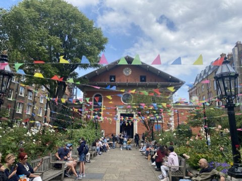 Inigo Place looking through bunting to the clock and pediment of St Paul's Covent Garden