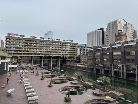 The Barbican lake seen from the terrace, residential blocks on the left, planters and benches along the water