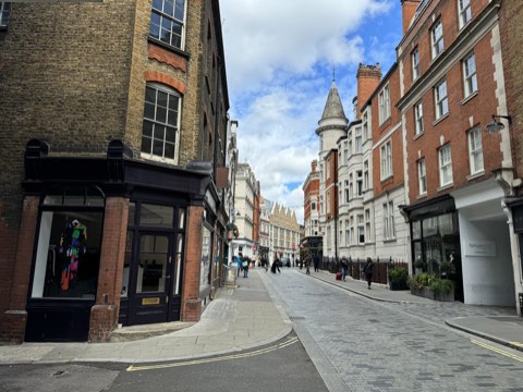 Marylebone Lane curving away between shopfronts, a red-brick turret above the street