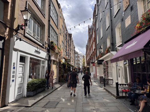 St Christopher's Place, a narrow flagstone lane with festoon lights, awnings and flower baskets