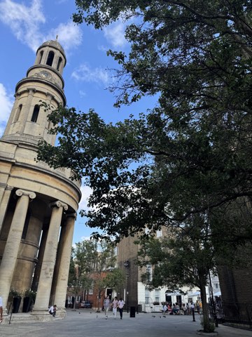 The circular portico and tower of St Mary's Bryanston Square seen from Wyndham Place through summer trees